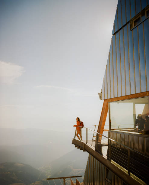 femme debout sur le balcon d’un refuge alpin moderne dans les dolomites - european alps women summer outdoor pursuit photos et images de collection