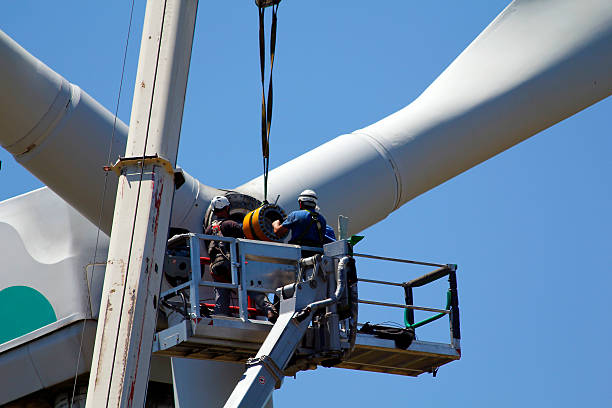 Repairing a wind turbine Operators do maintenance work on the turbine of a wind turbine industrial windmill stock pictures, royalty-free photos & images