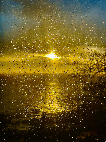 Rain Drops on Window looking at sunset background