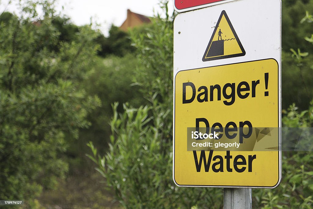 Deep Water warning sign A shot of a deep water, warning sign in front of foliage. Danger Stock Photo