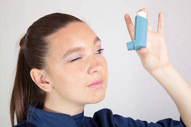 istock Cute girl looking in asthma inhaler 178974153