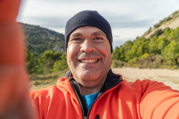 istock Happy man takes a selfie on the mountain at sunset. 1789751124