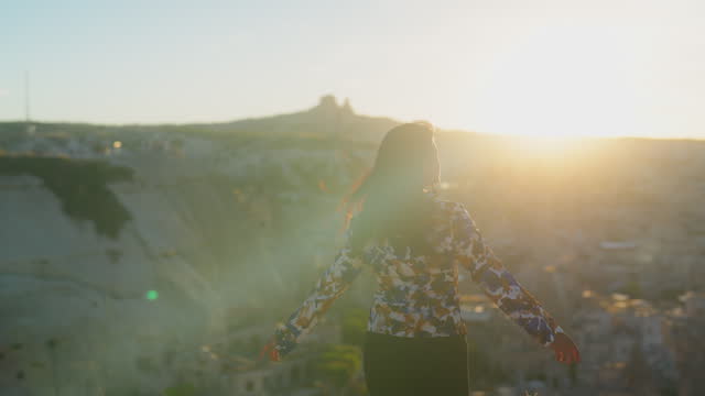 Portrait of multiracial woman watching the sunset on top of hill