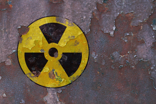 a weathered Radioactive sign on rusty metal