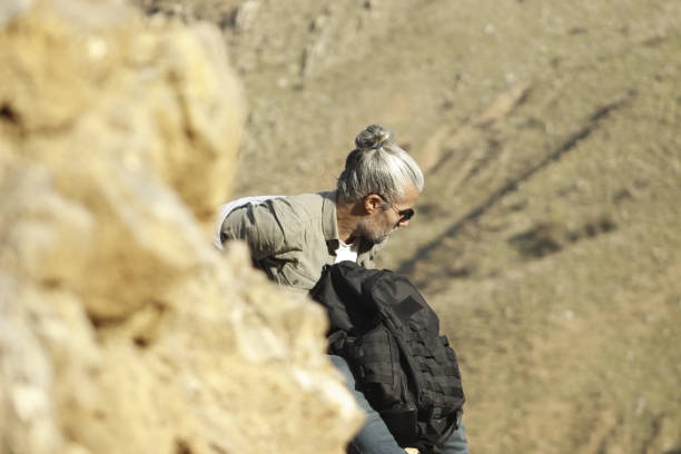 istock man walking, climbing, sitting and resting on the mountainside 1789779183