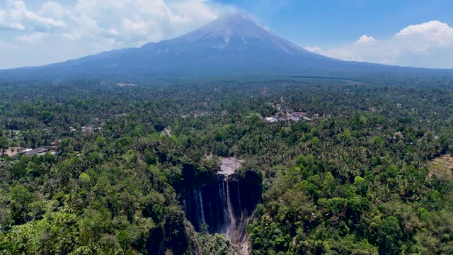 Aerial 4K footage of Tumpak Sewu, known as Coban waterfall and Semeru volcano