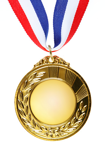 Close-up of golden medal on plain background