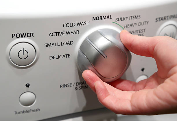 Hand turning on washing machine stock photo