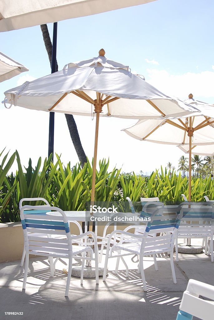 patio della piscina sedie, tavoli e ombrelloni - Foto stock royalty-free di Patio