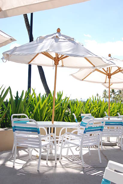patio della piscina sedie, tavoli e ombrelloni - umbrella poolside table dining foto e immagini stock
