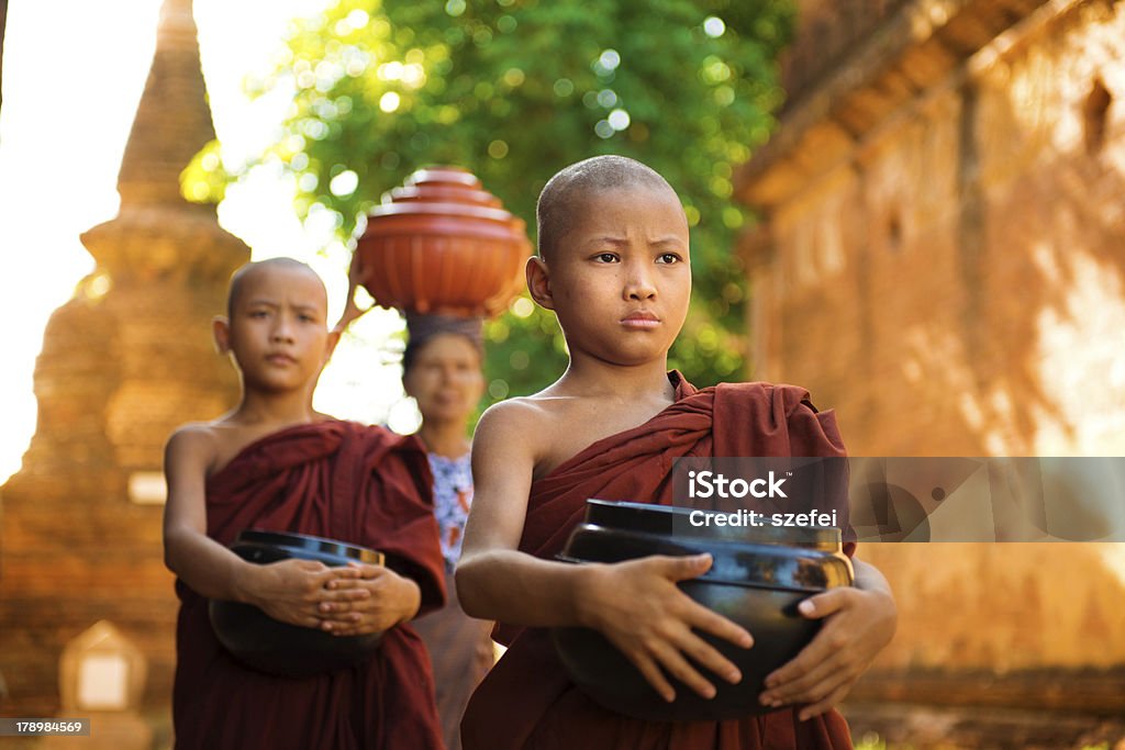 Buddhist monks Myanmar Young Buddhist monks walking morning alms in Old Bagan, Myanmar Asian and Indian Ethnicities Stock Photo
