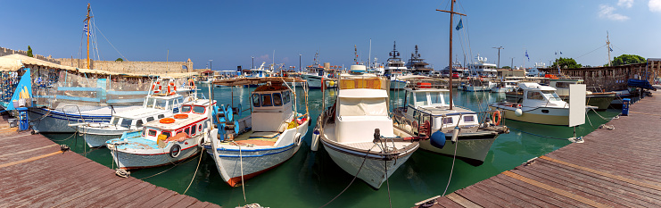 Panoramic view of traditional wooden fishing boats along the Rhodes waterfront. Greece.