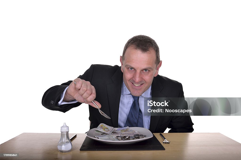 Tuck in image of a happy businessman eating a plate full of money Eating Stock Photo