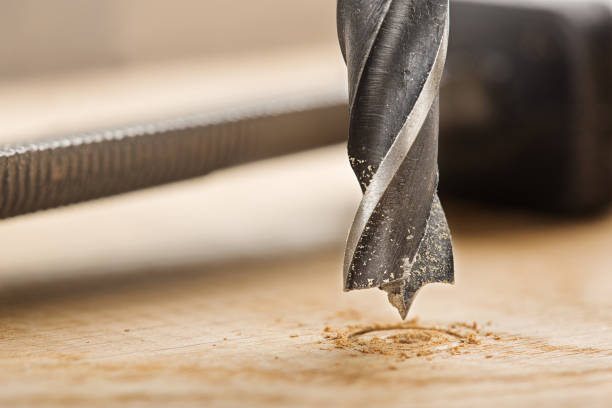 istock drill bit makes hole in wooden oak board for wooden dowel. 1789861818
