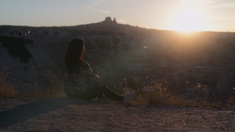 Multiracial female tourist watching the sunset on top of hill in Cappadocia in Türkiye Turkey