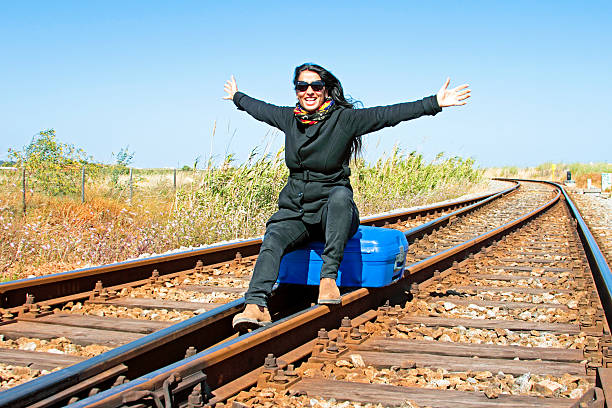 istock Young woman with her suitcase on a railroad track 178987373