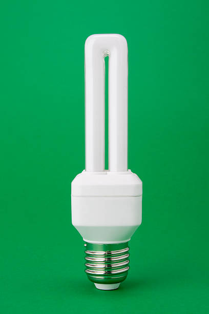 Energy saving light bulb on green background stock photo