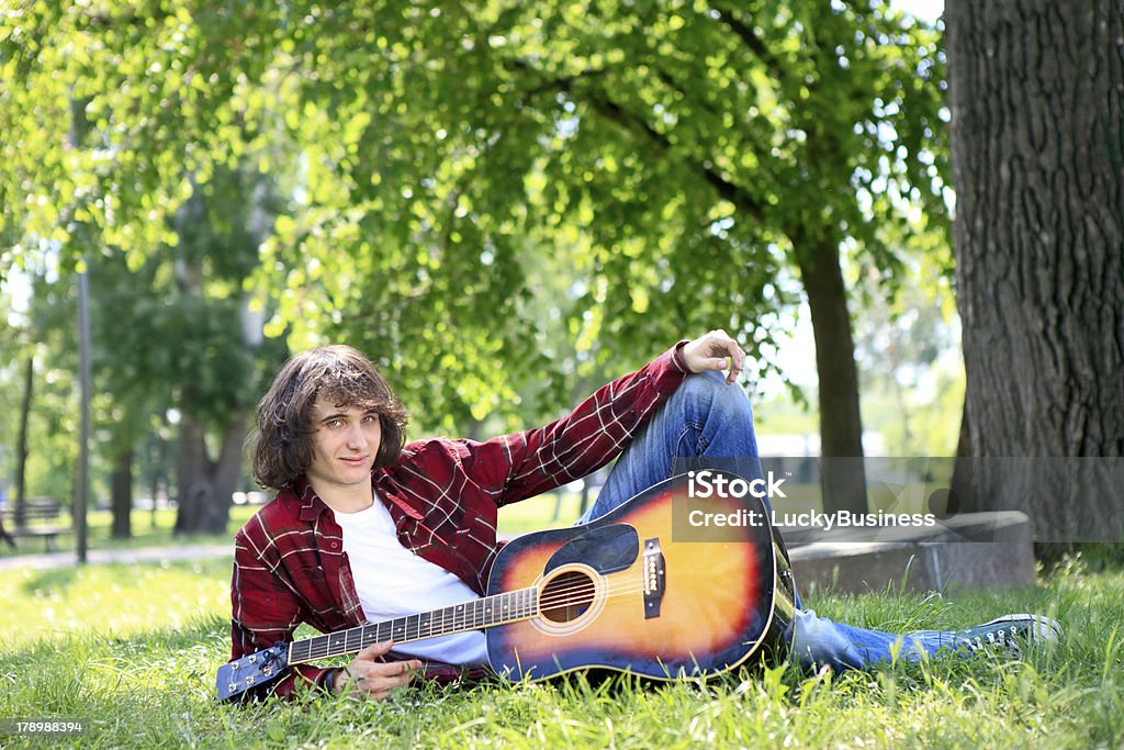 Homme dans un parc avec Guitare acoustique - Photo de Adolescent libre de droits