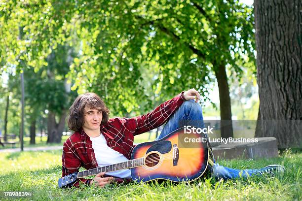 Człowiek W Parku Z Gitara Akustyczna - zdjęcia stockowe i więcej obrazów Dorosły - Dorosły, Drzewo, Fotografika