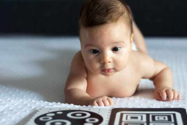 istock A baby looks at a black and white contrast educational book. Intellectual development of newborns. Developing cards for children. 1789885343