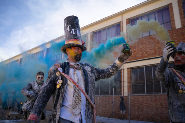 homem vestido de prefeito com bomba de fumaça azul na mão em tradicional batalha de farinha em ibi, espanha - firework display traditional festival bomb explosive - fotografias e filmes do acervo