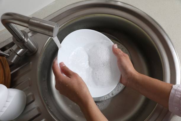 istock Woman washing plate in kitchen sink, above view 1789886943