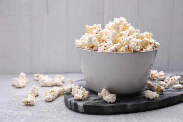 istock Bowl of tasty popcorn on grey table, space for text 1789886962