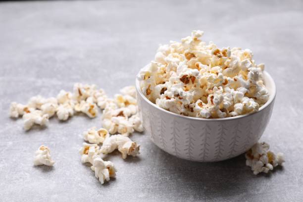 istock Bowl of tasty popcorn on grey table, space for text 1789887490