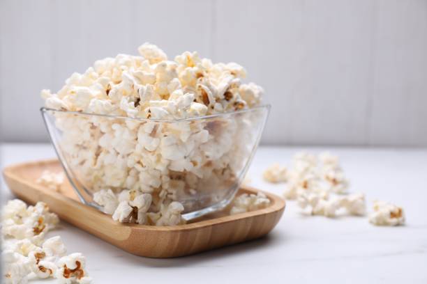istock Bowl of tasty popcorn on white table, closeup. Space for text 1789887492