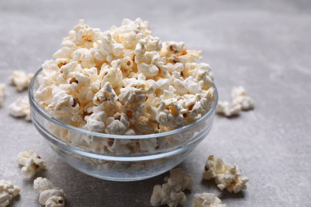 istock Bowl of tasty popcorn on grey table, closeup. Space for text 1789887508