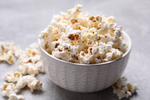 istock Bowl of tasty popcorn on grey table, closeup 1789887520