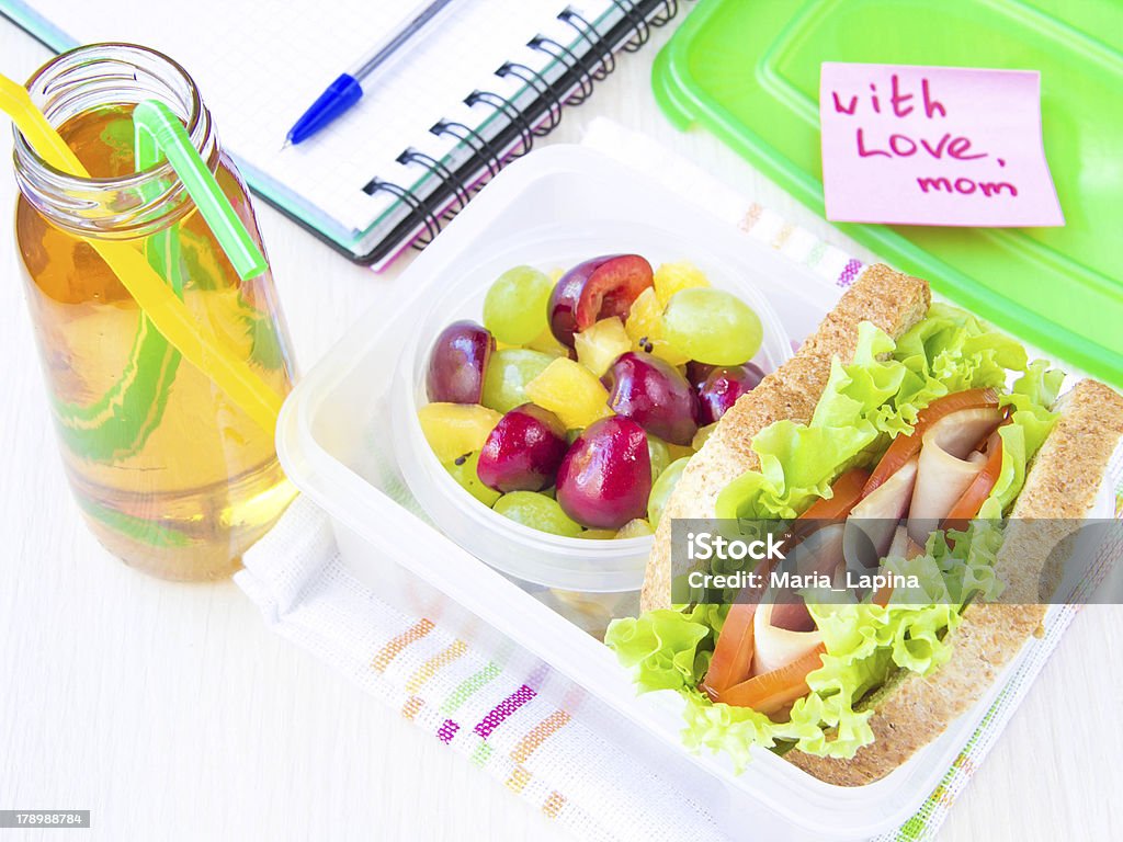 Bento lunch child in school, box with sandwich and fruit Bento lunch for your child in school, box with a healthy sandwich and fruit salad and apple juice in the bottle for drinking Appetizer Stock Photo