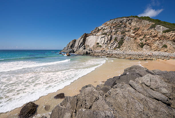 istock Sandy beach with calm waves surrounded by boulders and cliffs 178990813