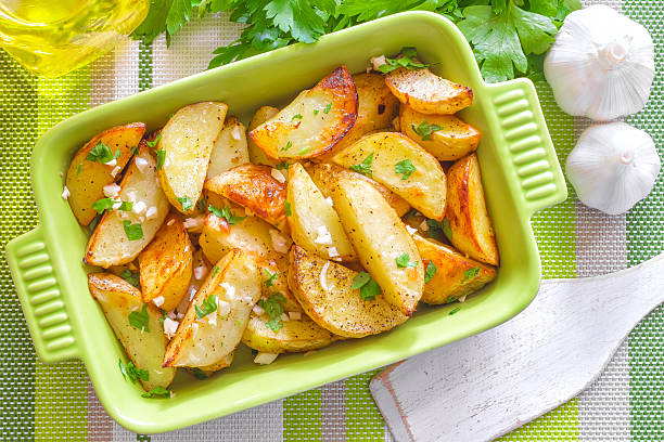 patate al forno - roasted potatoes prepared potato herb food foto e immagini stock