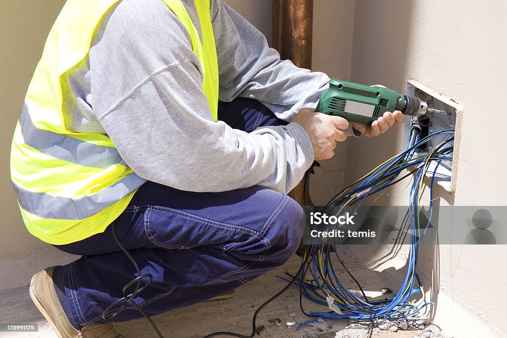 electrician at work electrician at work in a site Appliance Stock Photo