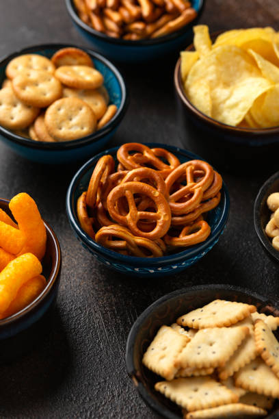 istock Salty snacks crackers, potato chips, pretzel, peanuts, corn puffs. 1789913916