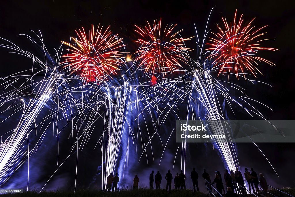 De grands feux d'artifice et des silhouettes d'observation de premier plan - Photo de Anniversaire d'un évènement libre de droits