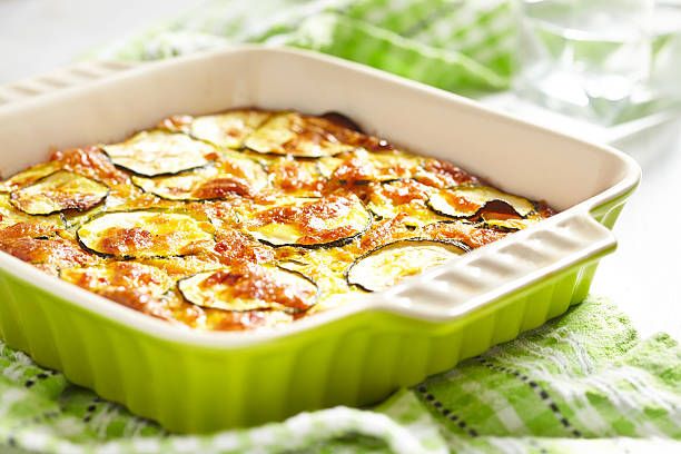 сыр запеканка с цуккини в выпекать блюдо и - zucchini gratin casserole squash стоковые фото и изображения