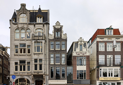 Amsterdam, Netherlands - April 21, 2023: Typical gabled houses on Damrak street in Amsterdam, Holland, Netherlands