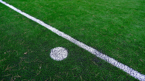 Photo of green synthetic grass sports field with white stripes