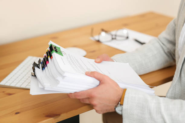istock Businessman with documents at wooden table in office, closeup 1789933446