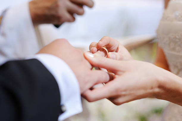 istock Bride putting a ring on groom's finger 178994815
