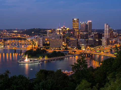 Under the veil of the night, the downtown Pittsburgh skyline harmoniously blends with the flowing rivers, connecting bridges, and the tranquil fountain at Point State Park. This nocturnal panorama unveils the city's mesmerizing beauty, where urban and natural elements coexist in perfect harmony.