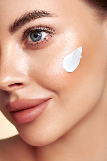 istock Beautiful woman applying moisturizer cream on her face 1789959175