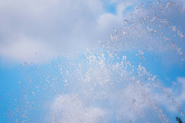 salpicaduras de agua contra el fondo azul del cielo - fountain water physical pressure splashing fotografías e imágenes de stock