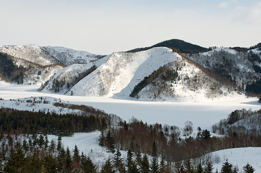 Winter lake under ice and white snow among the hills, Sakhalin island