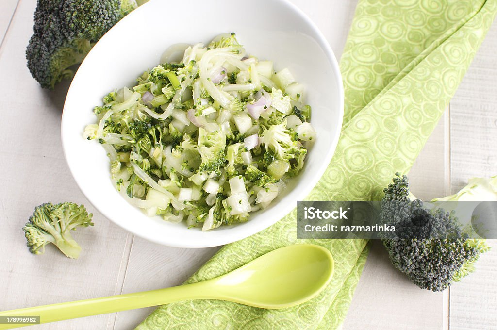 Bowl of green broccoli and cucumber salad Bowl of green broccoli and cucumber salad with onion Appetizer Stock Photo