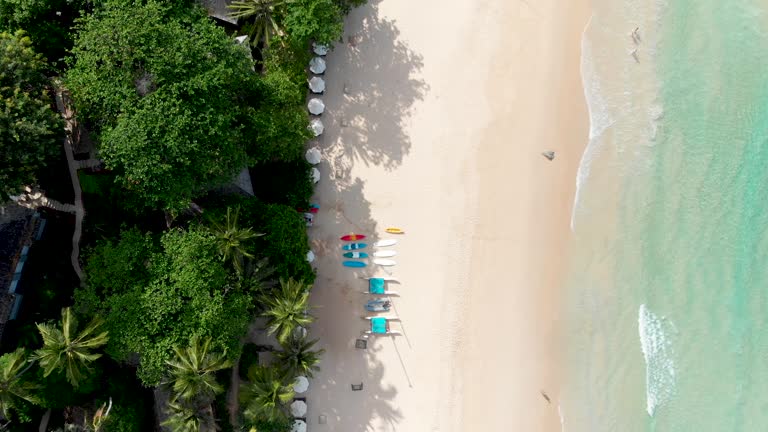 Fly-through aerial drone shot of Pansea Beach located in Phuket island, showing a pristine getaway for tourists in Thailand.