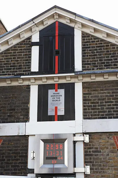 "The Prime meridian in Greenwich, London. A clock is showing the Greenwich Mean Time.he logo on the atomic clock has been removed."
