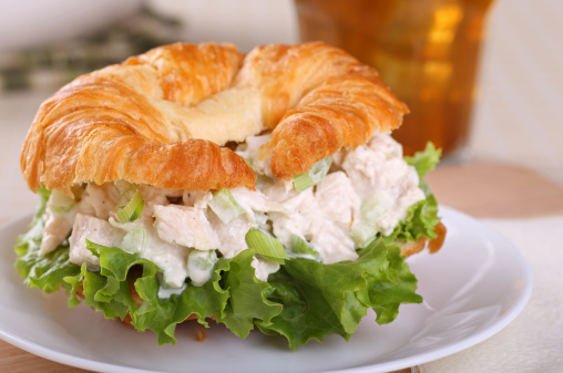 Closeup of a chicken salad and lettuce on a croissant roll
